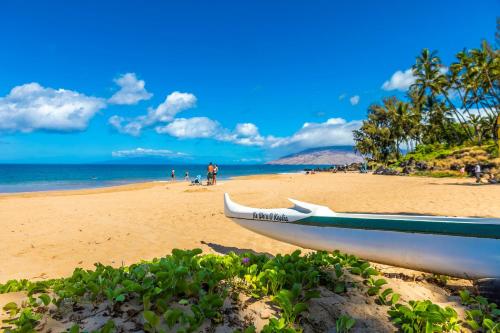 a boat sitting on a beach with the ocean at Kamaole Beach Royale 208 in Kihei