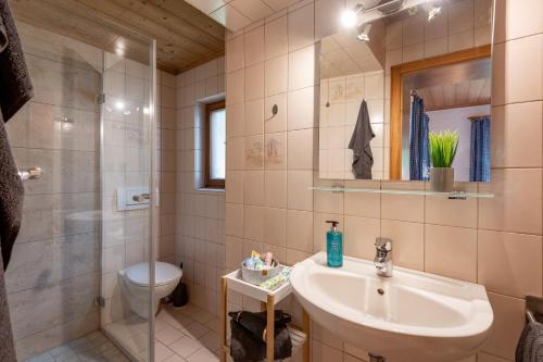 a bathroom with a sink and a shower and a toilet at Ferienwohnungen „Zum Bauern“ in Oberaudorf
