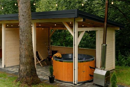 a hot tub in a gazebo with a tree at Tylawa - Domki w Beskidzie Niskim in Tylawa