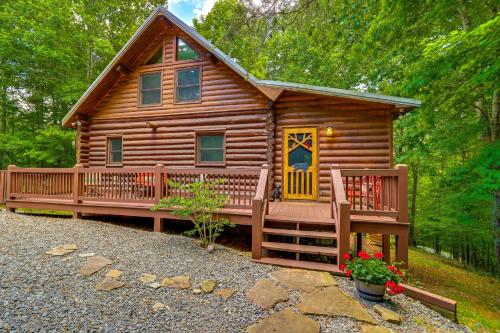 a cabin in the woods with a porch and a bench at Blue Ridge Log Cabin with Hot Tub and Game Room! in Blue Ridge