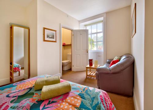 a bedroom with a bed and a chair and a mirror at Dol Peris in Llanberis