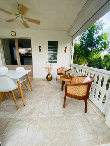 a porch with chairs and a table and a window at Appartement in Baie Nettle