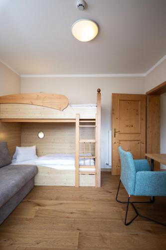 a room with a bunk bed and a couch and a chair at POST Family Resort in Unken