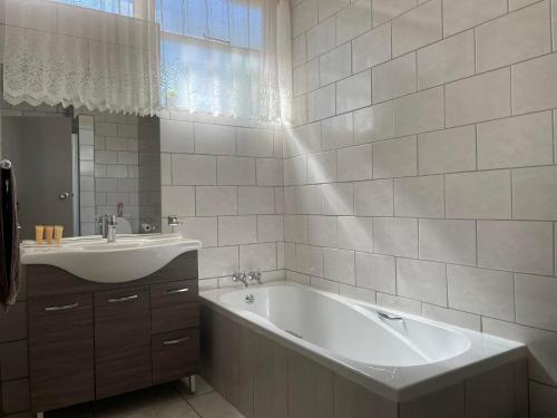 a white bathroom with a tub and a sink at LA Diamond Lodge & Safari in Lime Acres