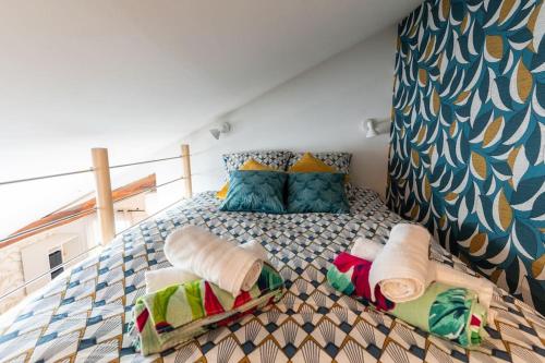 une chambre avec un lit avec des oreillers dessus dans l'établissement L'escapade vigne & bien-être, à Noizay