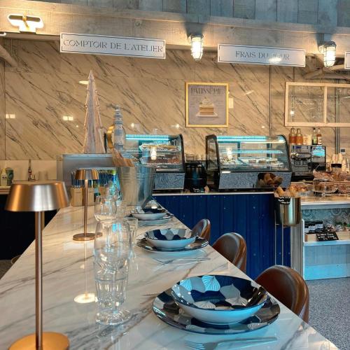 a long table with plates and glasses on it at Hôtel Expérience - Quartier Des Marinas in Magog-Orford
