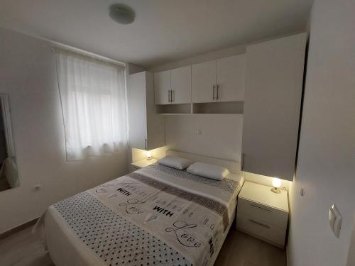 una piccola camera con un letto e due luci di Apartman Dubrovnik a Trogir