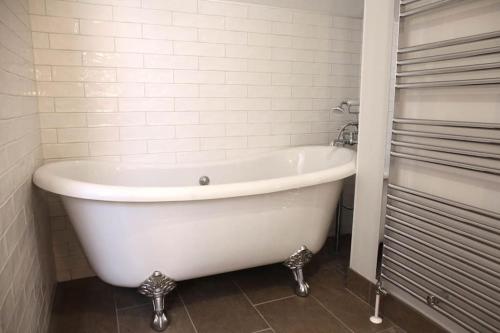 a white bath tub sitting in a bathroom at Luxury Pet-Friendly Retreat with Private Hot Tub in Boardmills