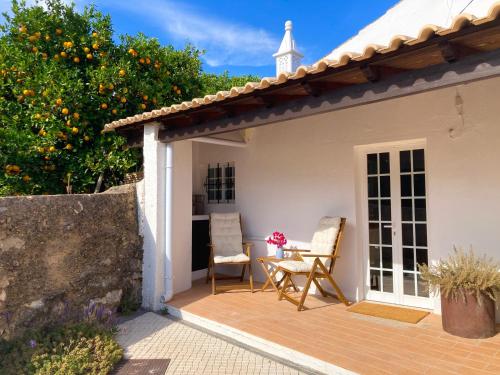 a patio of a house with two chairs and a table at Casinha Serena by east ALgarve guest in Santo Estêvão