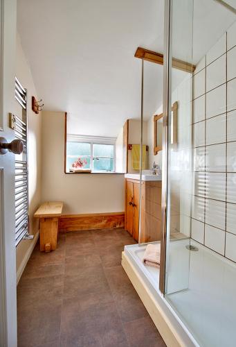 a bathroom with a glass shower and a sink at Dol Peris in Llanberis