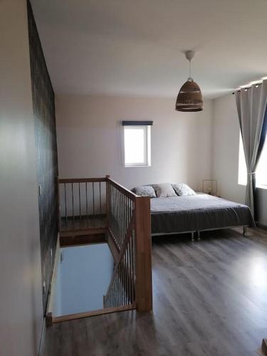 une chambre avec un lit et un escalier à l'intérieur dans l'établissement Duplex neuf avec extérieur, à Montbrison