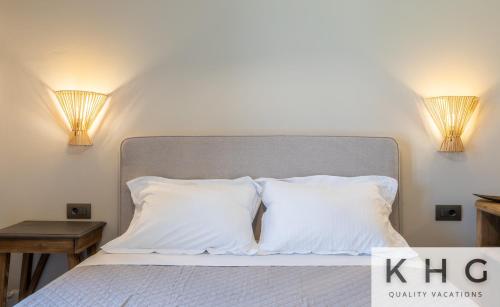 a bed with two white pillows and two lamps at Βιλα Ελευθερία με ιδιωτικη πισινα 5 λεπτα απο το Αργοστολι in Argostoli