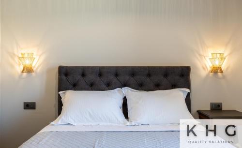 a bedroom with a bed with two pillows and two lights at Βιλα Ελευθερία με ιδιωτικη πισινα 5 λεπτα απο το Αργοστολι in Argostoli