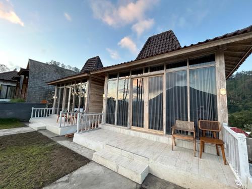 a house with a porch with a chair on it at The volcano in Kubupenlokan