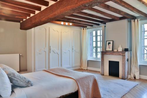 - une chambre avec un grand lit et une cheminée dans l'établissement Le Manoir de Mousseaux, à Romorantin-Lanthenay