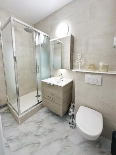 une salle de bain avec toilettes, douche et lavabo dans l'établissement Les Saules, à Dinard