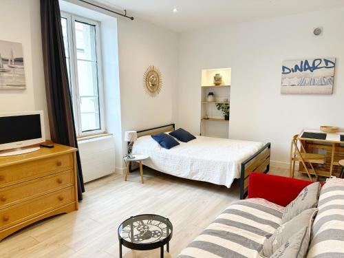 une petite chambre avec un lit et un canapé dans l'établissement Les Saules, à Dinard