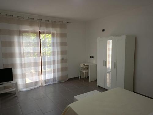 a white room with a bed and a television at bed and breakfastEuropa in Trentinara