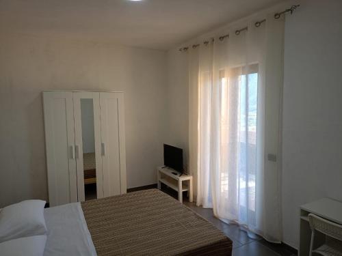 a bedroom with a bed and a television and a window at bed and breakfastEuropa in Trentinara