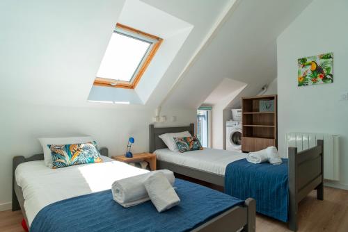 - une chambre mansardée avec 2 lits et une fenêtre dans l'établissement Casa Azul - Maison proche de la plage, à Sarzeau