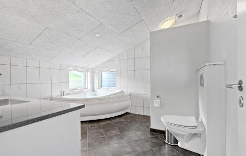 a white bathroom with a tub and a toilet at 3 Bedroom Beautiful Home In Hovborg in Hovborg