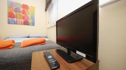 a flat screen tv sitting on a table with a remote control at Studio 47B in London