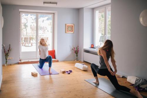 two women doing yoga in a living room at Design Hotel Miramonte in Bad Gastein