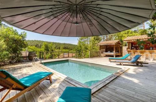 une piscine avec des chaises et un parasol dans l'établissement Villa de Charme La Dune, à Seignosse