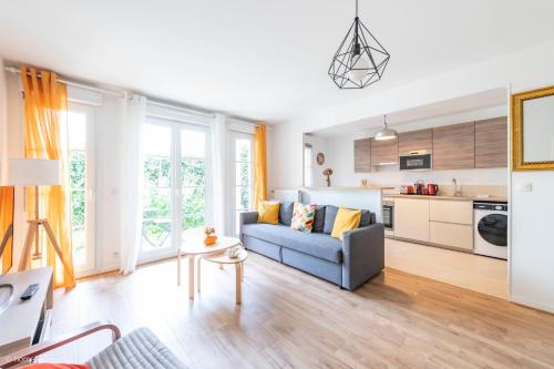 un salon avec un canapé bleu et une cuisine dans l'établissement Charmant T3 familial pour 8, 5min Disney, 2Parkings, à Serris