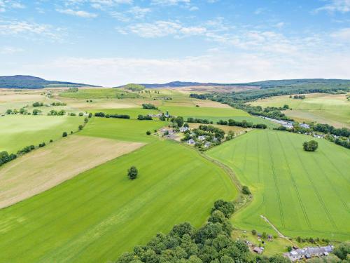 an aerial view of a green field with trees at InEdra Estate Farmhouse by edradour1725 in Pitlochry