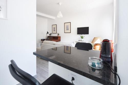 a kitchen with a counter top and a room at Sintra Sweet Apartment I - Free Parking in Sintra