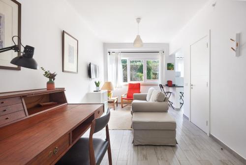 a white living room with a table and a couch at Sintra Sweet Apartment I - Free Parking in Sintra