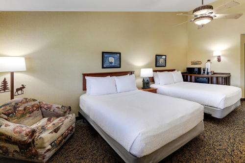 a hotel room with two beds and a couch at Stoney Creek Hotel La Crosse - Onalaska in Onalaska