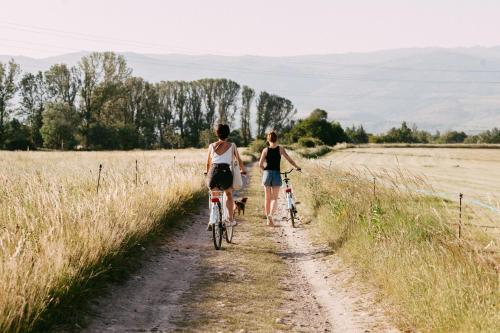 two women riding bikes down a dirt road in a field at Mas Sant Marc in Puigcerdà