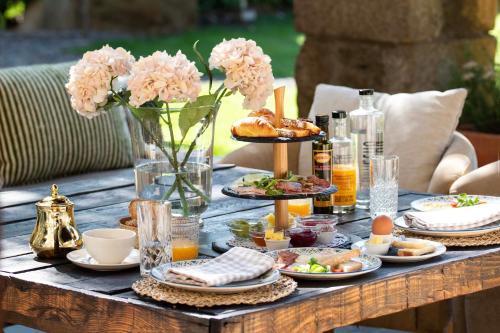 a table with plates of food and flowers on it at Mas Sant Marc in Puigcerdà