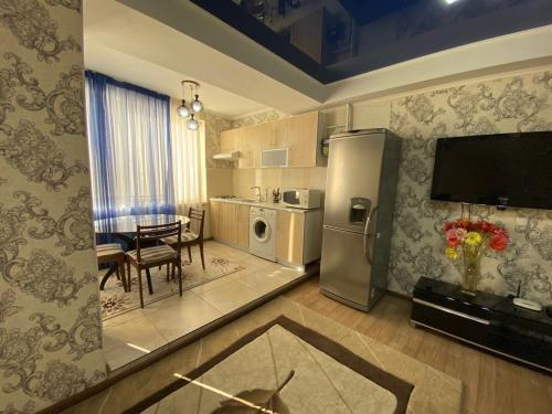 cocina y comedor con nevera de acero inoxidable en Квартира в центре, VEFA, en Bishkek