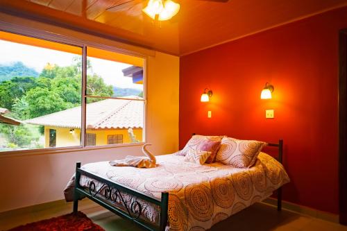 a bed in a room with a large window at Hotel Central Boquete in Boquete
