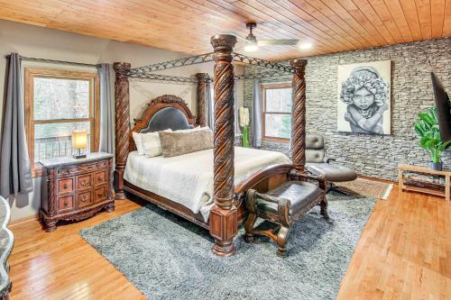 a bedroom with a canopy bed and a stone wall at Riverfront Lake Lure Lodge with Deck on 13 Acres in Lake Lure