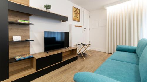 a living room with a blue couch and a television at Stop & Relax - Parking in Porto