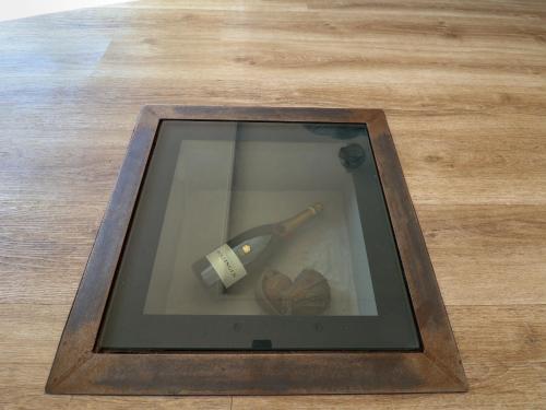 a framed picture of a bottle of wine and a heart at Dolly's House in Sandbach