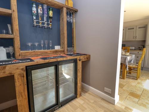 a tasting room with a counter with glasses on the wall at Dolly's House in Sandbach