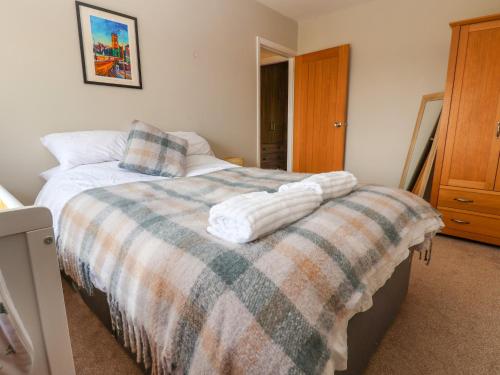 a bedroom with a bed with a blanket on it at Dolly's House in Sandbach