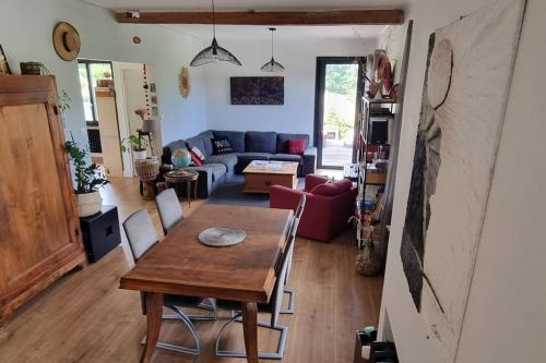 een woonkamer met een tafel en een bank bij Maison avec vue imprenable in Saint-Martin-de-Clelles