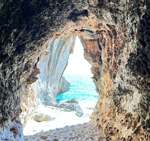 a view of the ocean through a rock cave at Casa M&M in Cala Gonone