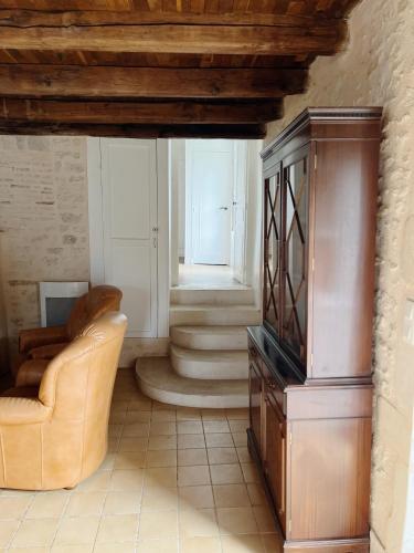un salon avec une chaise et une télévision dans l'établissement Gîte des Lavandières en bordure de Vienne (Civaux), à Salles-en-Toulon
