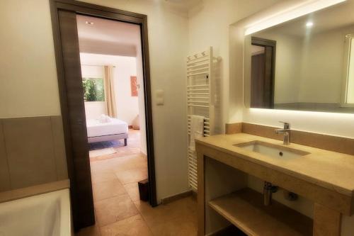 une salle de bain avec un lavabo, un miroir et une baignoire dans l'établissement Villa piscine vue sur le golfe de Saint-Tropez, à Grimaud