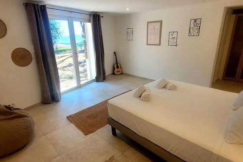 une chambre avec un grand lit et une grande fenêtre dans l'établissement Villa piscine vue sur le golfe de Saint-Tropez, à Grimaud