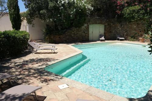 - une piscine avec banc à côté d'un bâtiment dans l'établissement Villa piscine vue sur le golfe de Saint-Tropez, à Grimaud