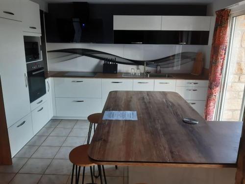 a kitchen with a wooden table and some chairs at Très belle maison bretonne in Pluvigner