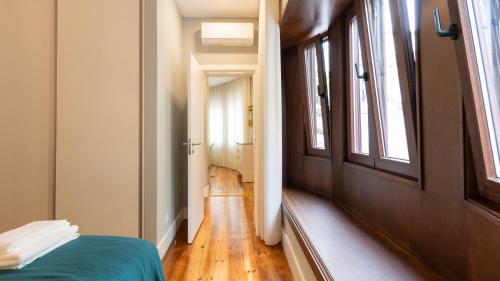 a room with a bed and a hallway with a window at Stop & Relax - Parking in Porto